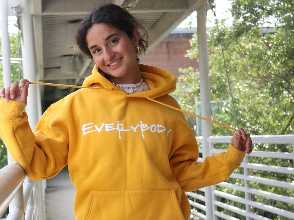 model wearing yellow unisex logo hoodie